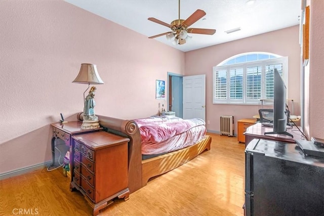 bedroom with ceiling fan, radiator, and wood-type flooring