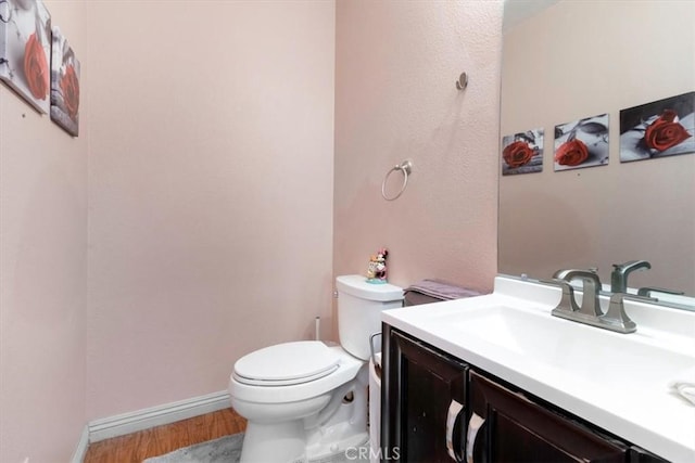 bathroom featuring hardwood / wood-style floors, toilet, and vanity