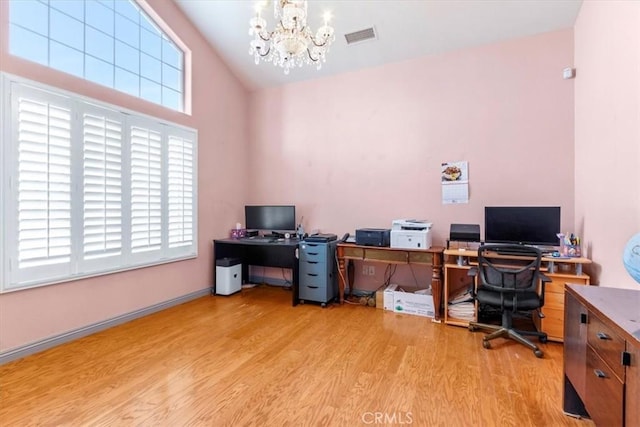 office area featuring a notable chandelier and light wood-type flooring