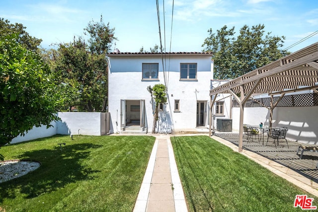 back of property featuring a pergola, central air condition unit, and a yard