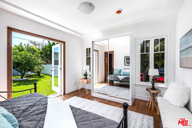 bedroom with access to outside, a closet, and dark hardwood / wood-style floors