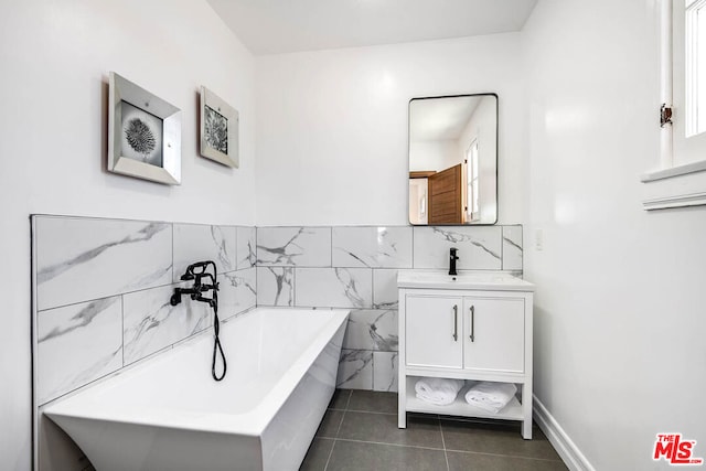 bathroom with vanity, tile walls, tile patterned floors, and a washtub