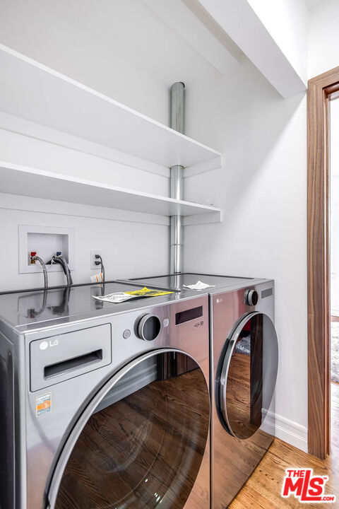 washroom featuring washing machine and dryer and light hardwood / wood-style floors