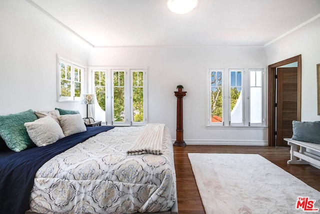 bedroom with dark hardwood / wood-style floors and ornamental molding