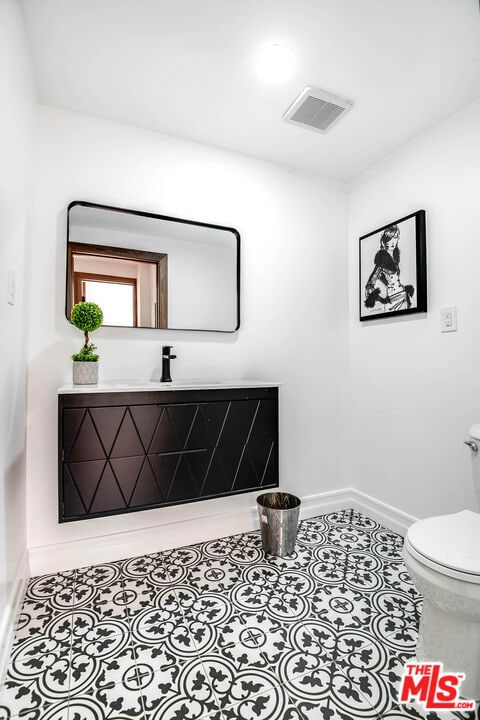 bathroom featuring toilet, vanity, and tile patterned floors