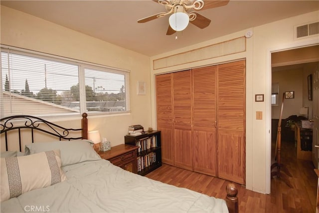 bedroom featuring ceiling fan, a closet, and wood-type flooring