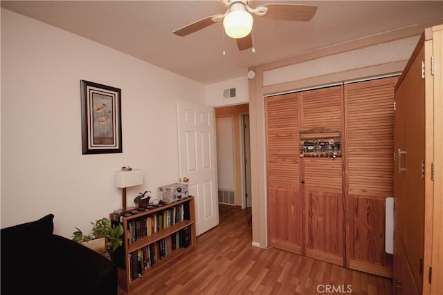 bedroom featuring a closet, light hardwood / wood-style floors, and ceiling fan