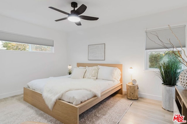 bedroom featuring multiple windows, ceiling fan, and light hardwood / wood-style floors