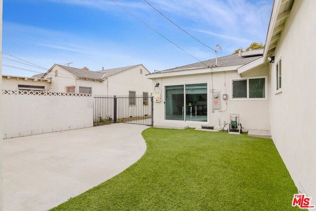 rear view of house featuring a yard and a patio area