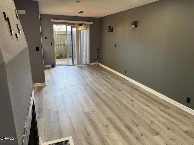 unfurnished dining area featuring light hardwood / wood-style flooring and an inviting chandelier