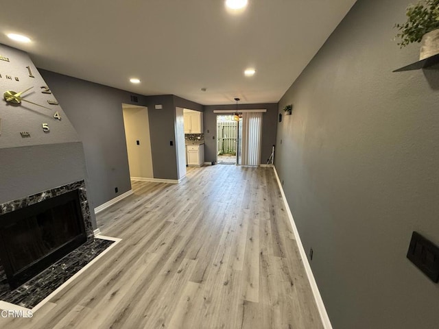 living room featuring light wood-type flooring and a notable chandelier