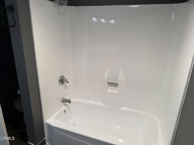 bathroom with tub / shower combination and toilet