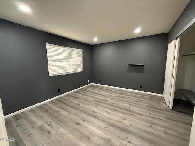 unfurnished bedroom with a closet and light hardwood / wood-style flooring