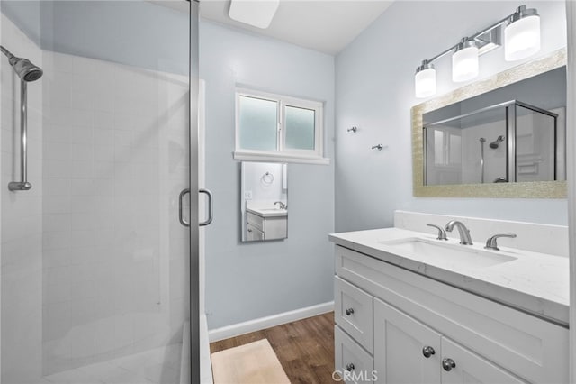 bathroom featuring walk in shower, wood-type flooring, and vanity