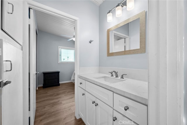 bathroom featuring ceiling fan, hardwood / wood-style floors, and vanity