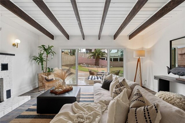 living room with dark wood-type flooring, a fireplace, and beamed ceiling