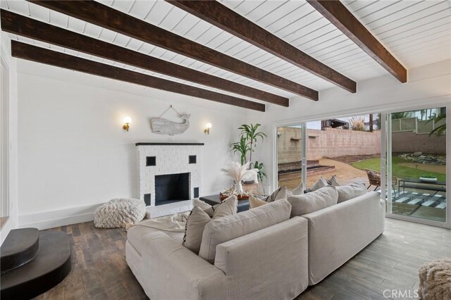 living room with a brick fireplace, wood ceiling, and beam ceiling