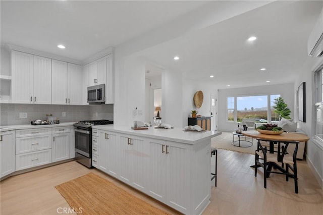 kitchen featuring appliances with stainless steel finishes, white cabinetry, and tasteful backsplash