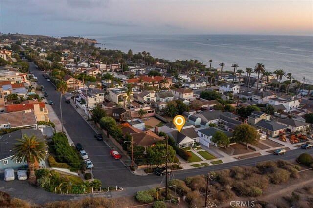 aerial view at dusk featuring a water view