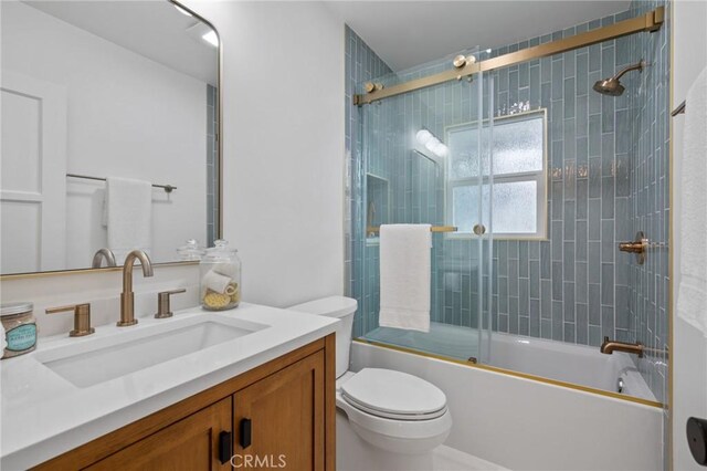 full bathroom featuring toilet, enclosed tub / shower combo, and vanity