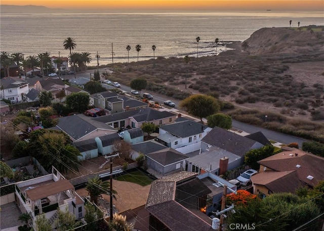 aerial view at dusk featuring a water view