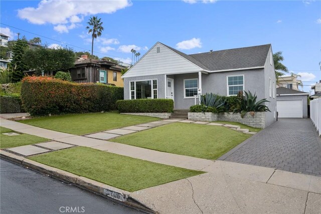 view of front of property with a front yard, a garage, and an outbuilding