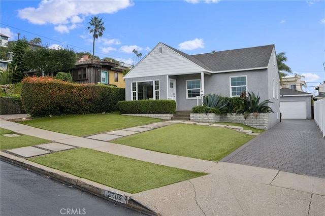 view of front of home featuring a front lawn, an outdoor structure, and a garage