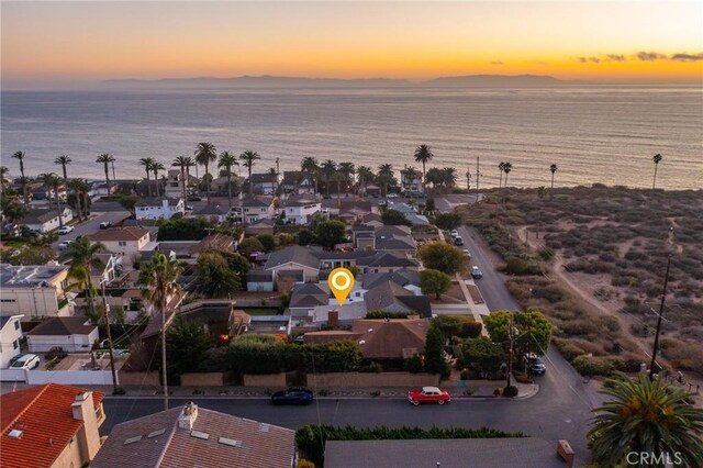 aerial view at dusk featuring a water view