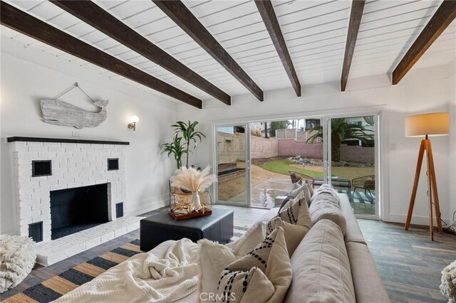 living room featuring a brick fireplace, dark hardwood / wood-style flooring, and beamed ceiling