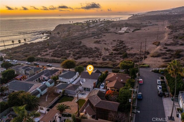 aerial view at dusk featuring a water view