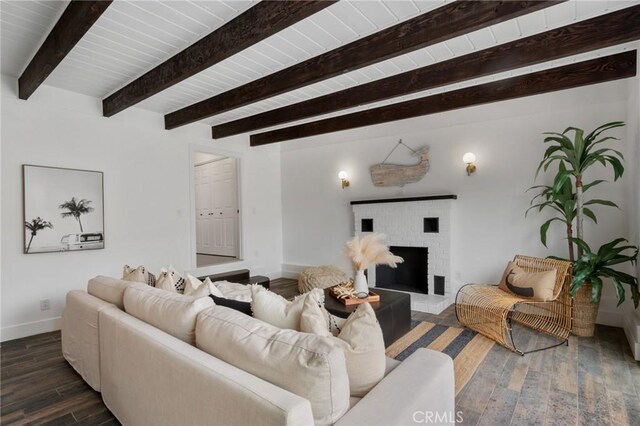 living room with a brick fireplace and beam ceiling