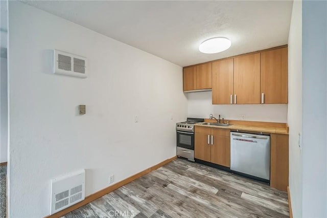 kitchen with light wood-type flooring, sink, and stainless steel appliances