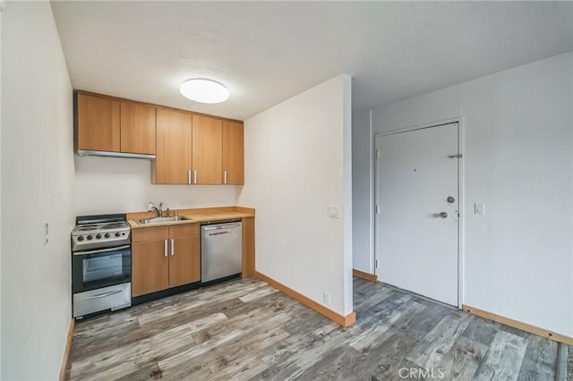 kitchen with sink, appliances with stainless steel finishes, and light wood-type flooring