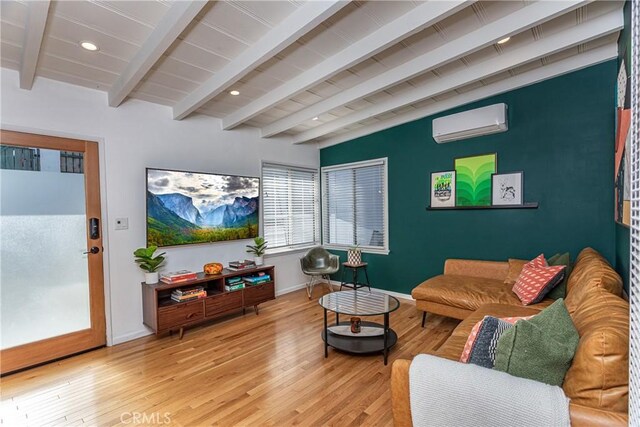 living room featuring a wall unit AC, light hardwood / wood-style flooring, and lofted ceiling with beams