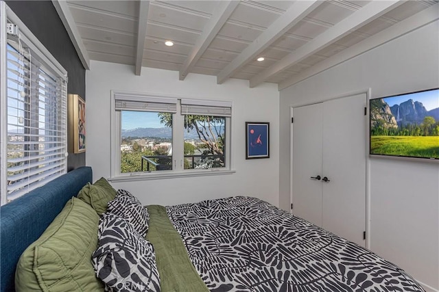 bedroom featuring lofted ceiling with beams and multiple windows