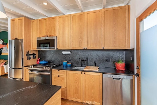 kitchen with tasteful backsplash, beam ceiling, sink, appliances with stainless steel finishes, and light brown cabinetry