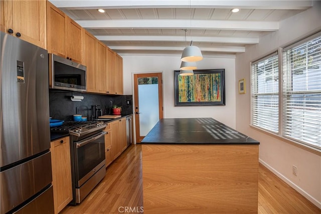 kitchen featuring a kitchen island, appliances with stainless steel finishes, beamed ceiling, and tasteful backsplash