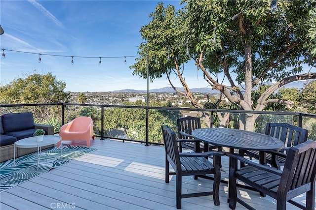 deck with outdoor lounge area and a mountain view