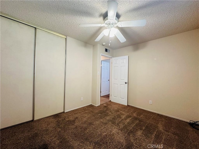 unfurnished bedroom featuring a textured ceiling, ceiling fan, a closet, and carpet floors