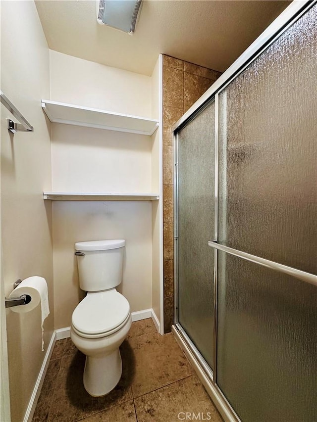 bathroom with toilet and a shower with shower door