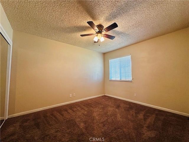 empty room with ceiling fan, a textured ceiling, and carpet flooring