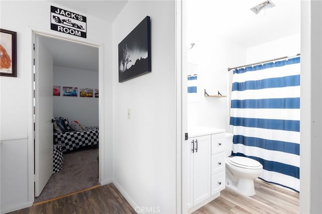 bathroom with toilet, hardwood / wood-style floors, and vanity