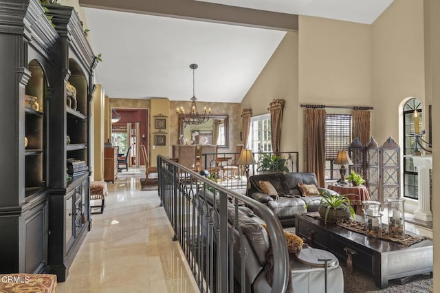 living room featuring high vaulted ceiling and an inviting chandelier