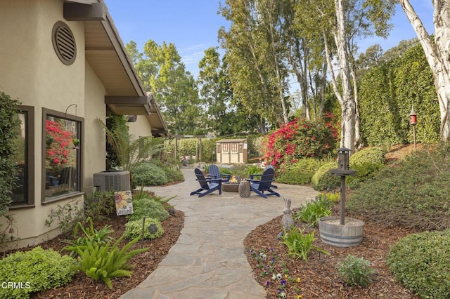 view of patio / terrace with cooling unit and a fire pit