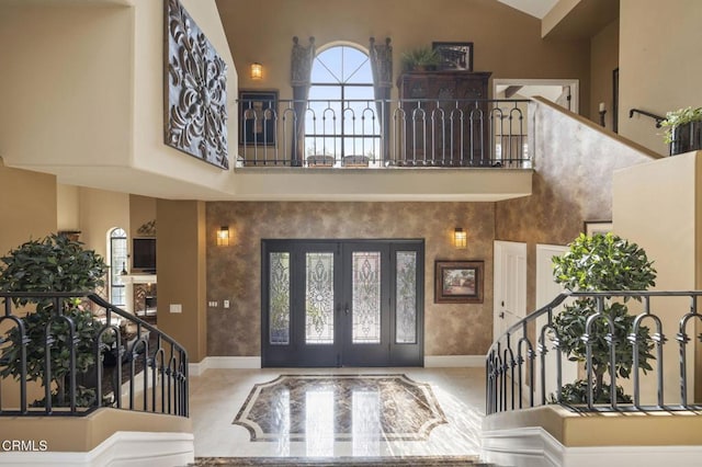 foyer with high vaulted ceiling and french doors