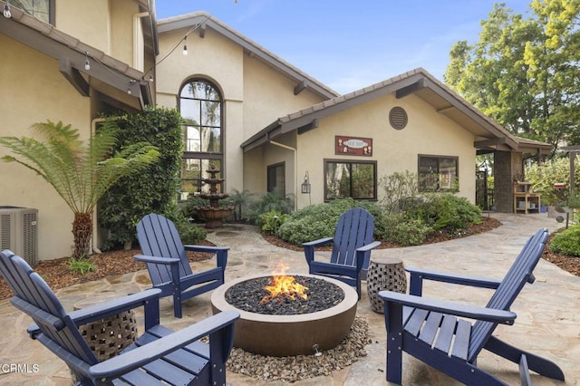 exterior space featuring an outdoor fire pit and central air condition unit