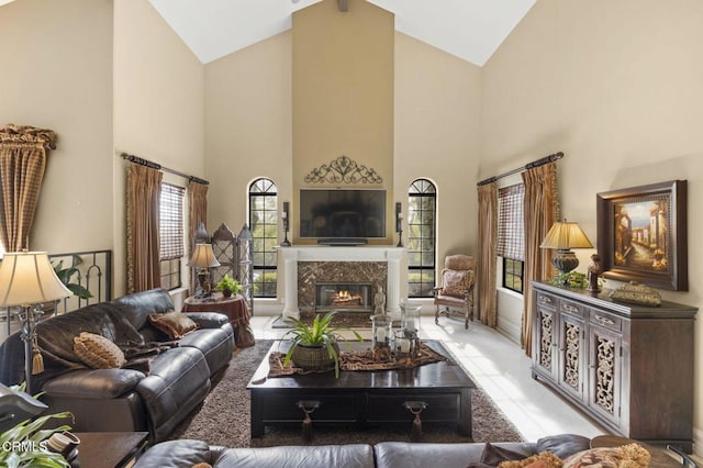 living room with high vaulted ceiling and a high end fireplace