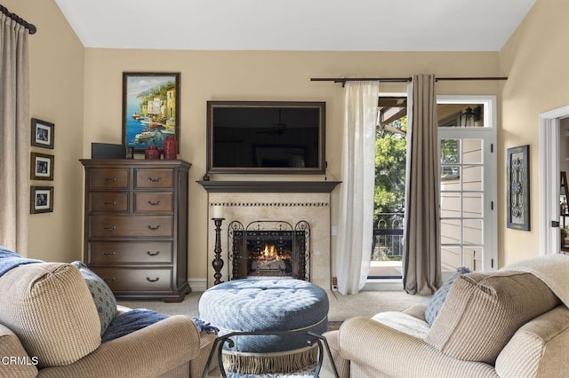 carpeted living room featuring a tile fireplace