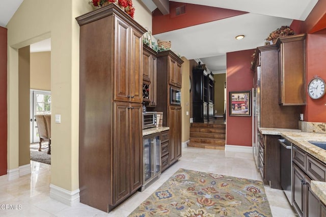 kitchen featuring light stone counters, light tile patterned floors, stainless steel appliances, and wine cooler