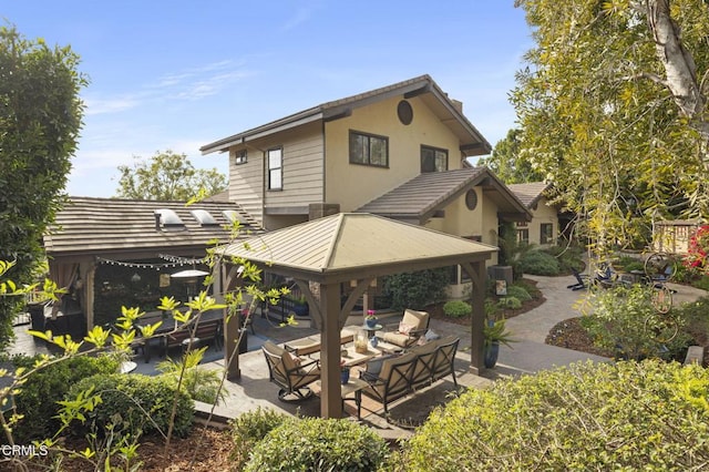 back of house featuring central AC unit, a gazebo, outdoor lounge area, and a patio